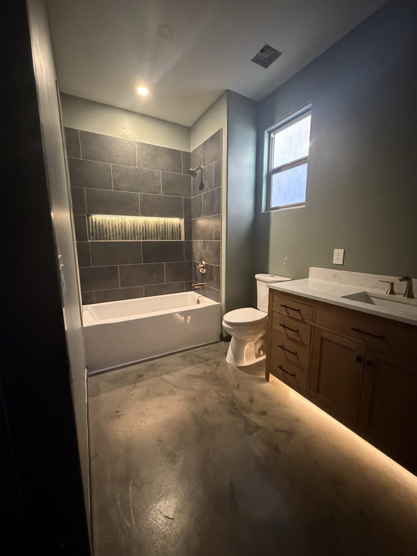 Finished bathroom with tile, stained concrete floor, and LED lighting